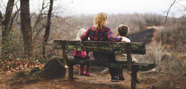 Woman sitting with two children on a bench